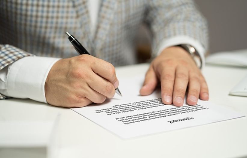 NetBet firma un acuerdo de contenidos con Gaming Realms 1 persona-firmando-un-acuerdo