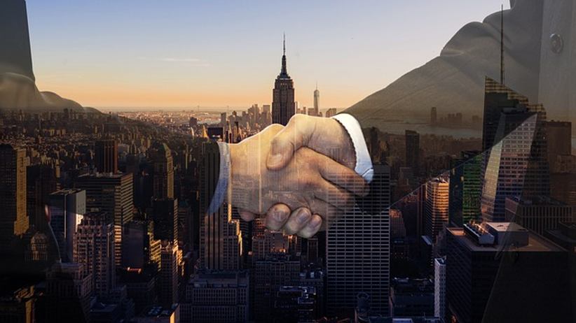 NuxGame firma una nueva asociación estratégica con Apcopay 1 empresarios-se-estrechan-manos-paisaje-urbano-antecedentes