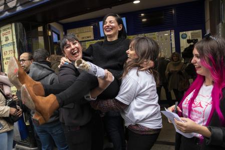 El sorteo del Euromillones deja este pastizal para un único acertante en España 2 Ganadores de lotería celebrando frente a una administración